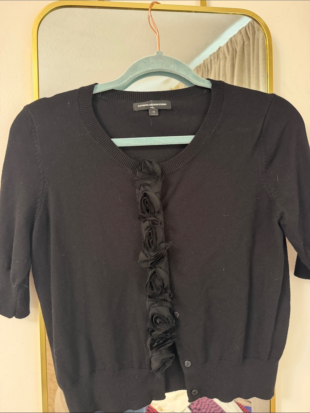 Women's black short-sleeve button-front top with ruffle trim